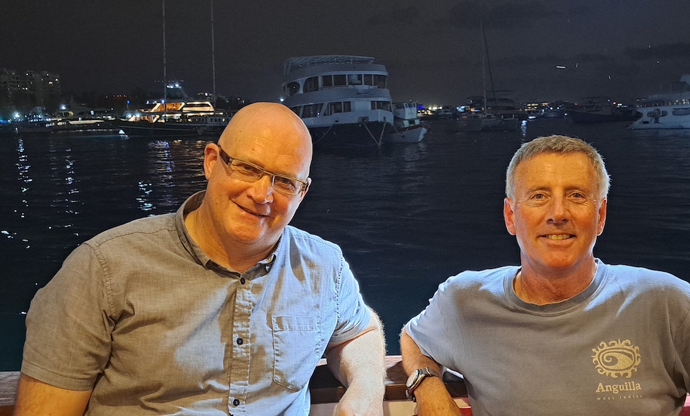 Two men sitting and smiling into the camera