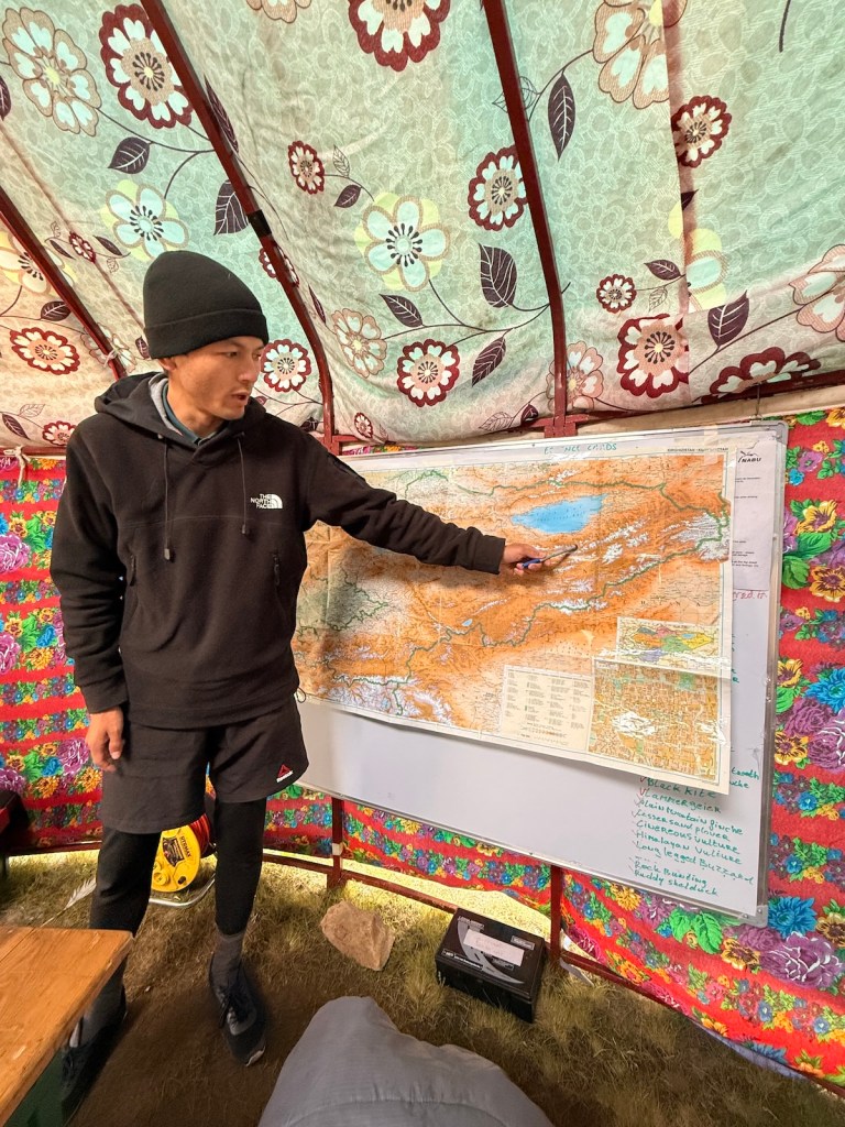 Man pointing at a map in a yurt